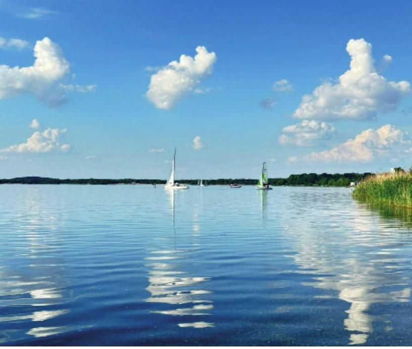 Segelboote auf einem See bei blauem Himmel.